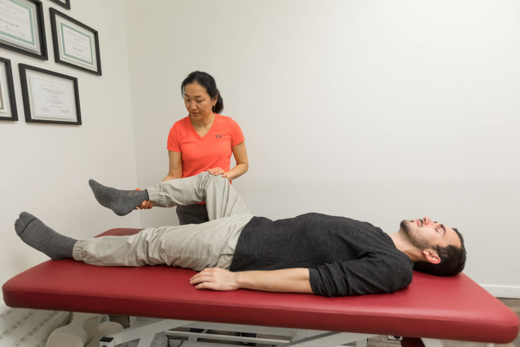 patient lying while Soulphysio professional check his pelvis health